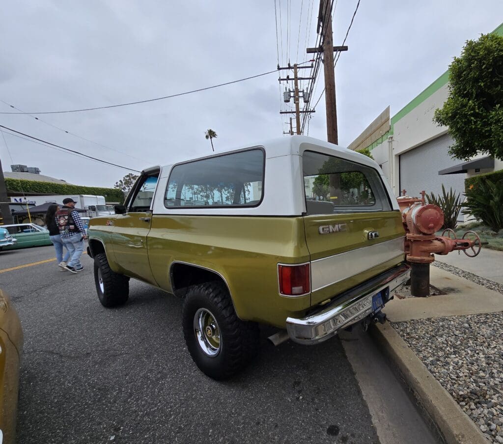 Vintage green and gold two-tone pickup truck parked on a street.