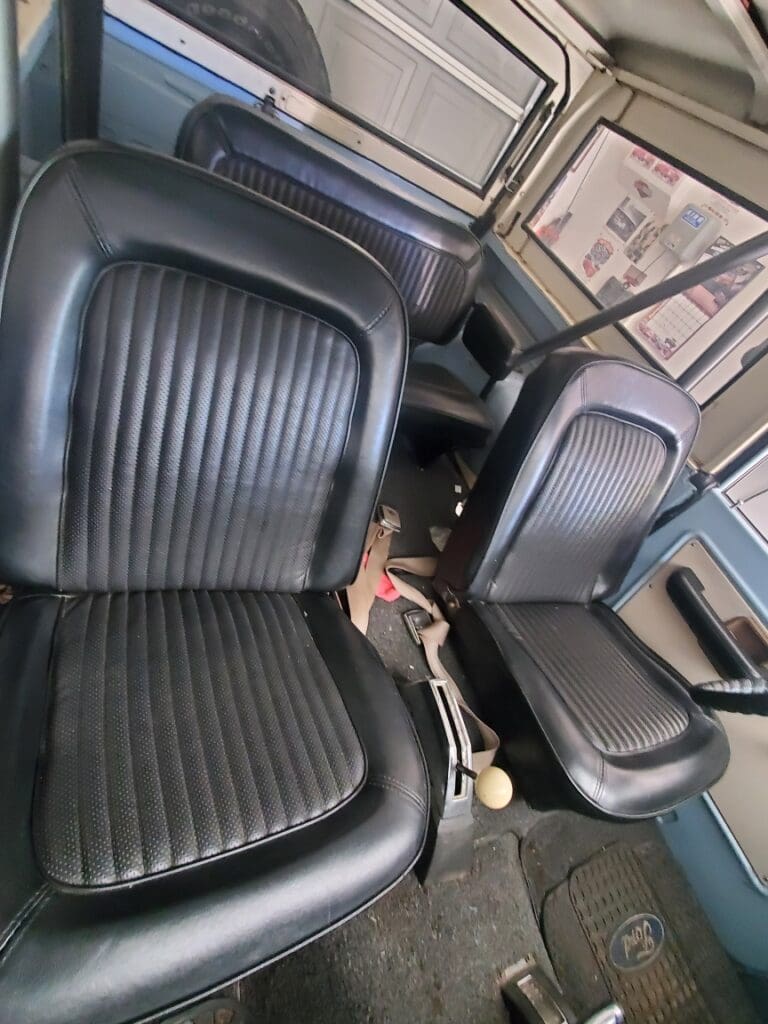 Two black leather car seats inside a vehicle.