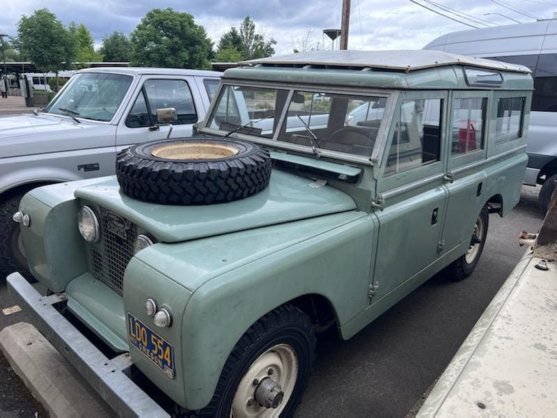 Vintage green off-road vehicle with a spare tire mounted on the hood.