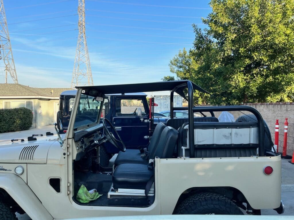 Classic white convertible Jeep parked outdoors on a sunny day.