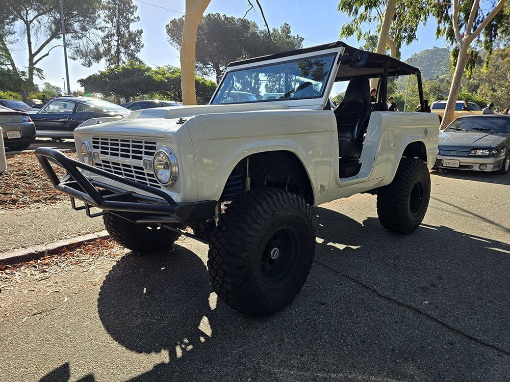 Classic off-road vehicle with large tires and open doors parked outdoors.