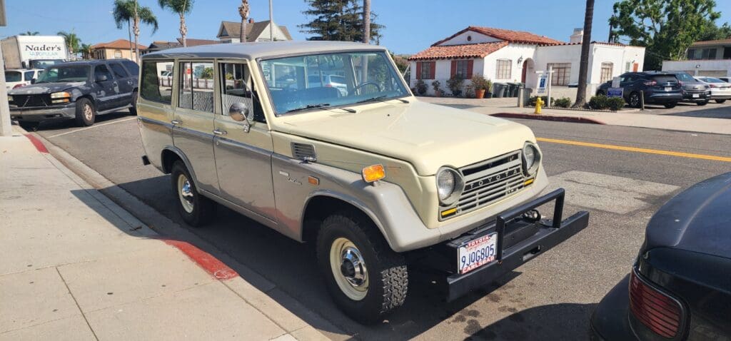 Classic beige off-road vehicle parked on a sunny street.