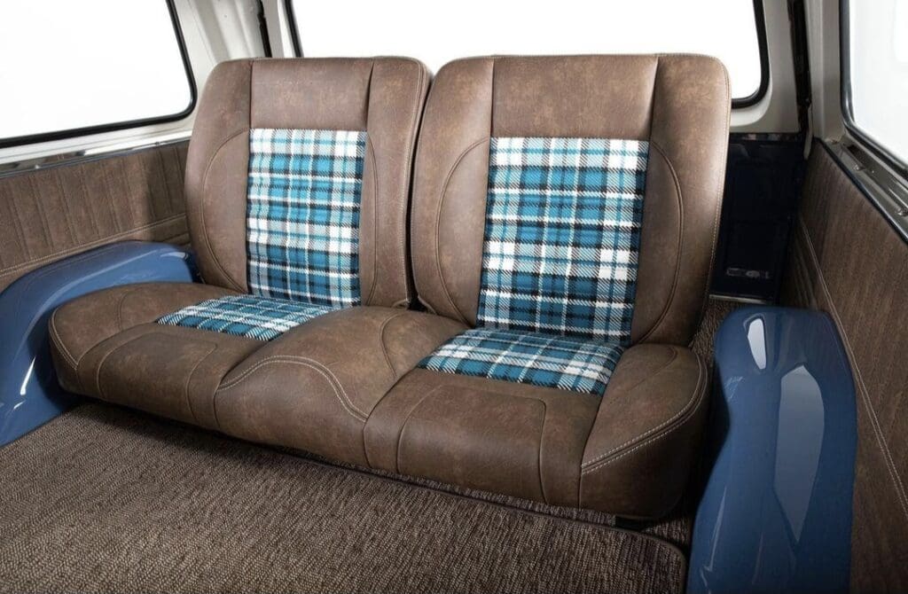 Vintage brown leather car seats with blue plaid fabric inserts.