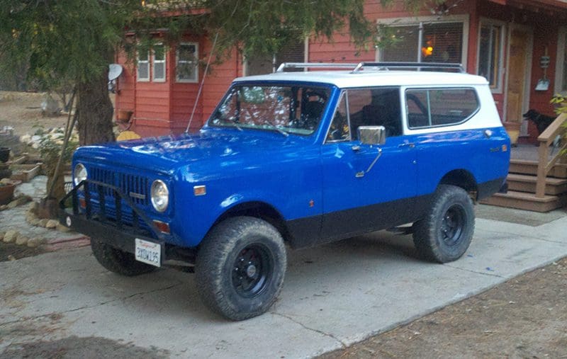Vintage blue off-road vehicle parked in a driveway.