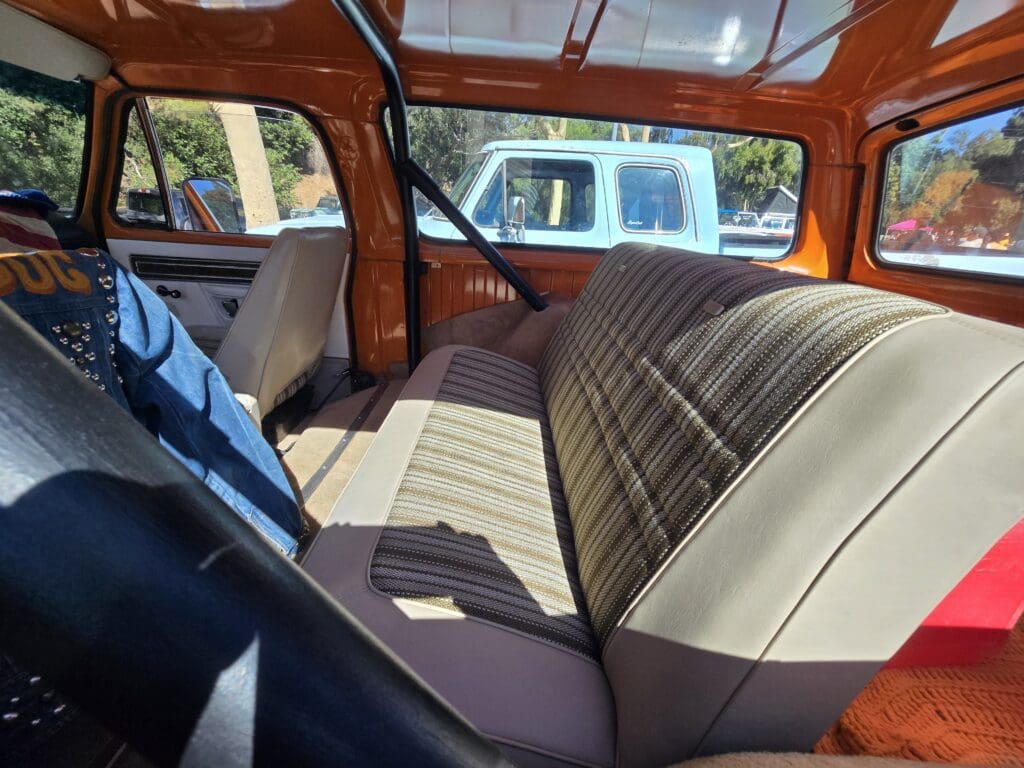 Interior of a vintage vehicle with brown seats and a blue steering wheel.