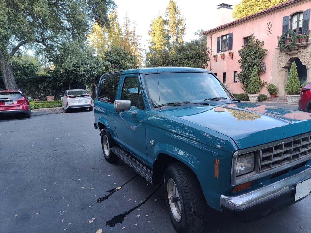 Blue vintage SUV parked on a residential street.