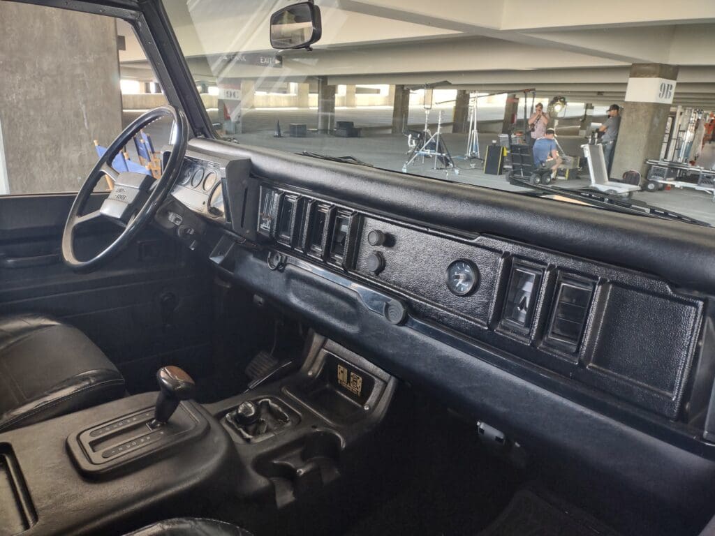 Interior view of a vintage car dashboard with manual gear shift.