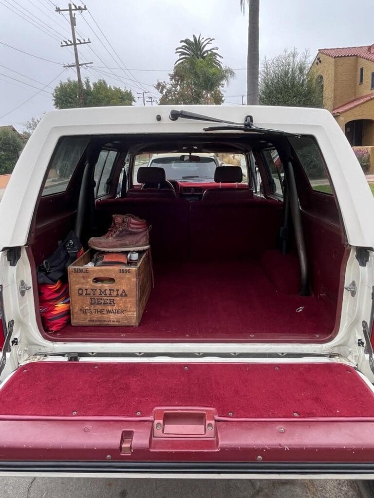 Open rear hatch of a white vehicle with boxes inside.