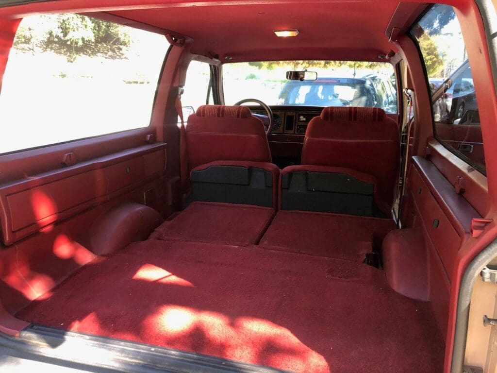 Spacious red interior of a vehicle's cargo area with foldable seats.