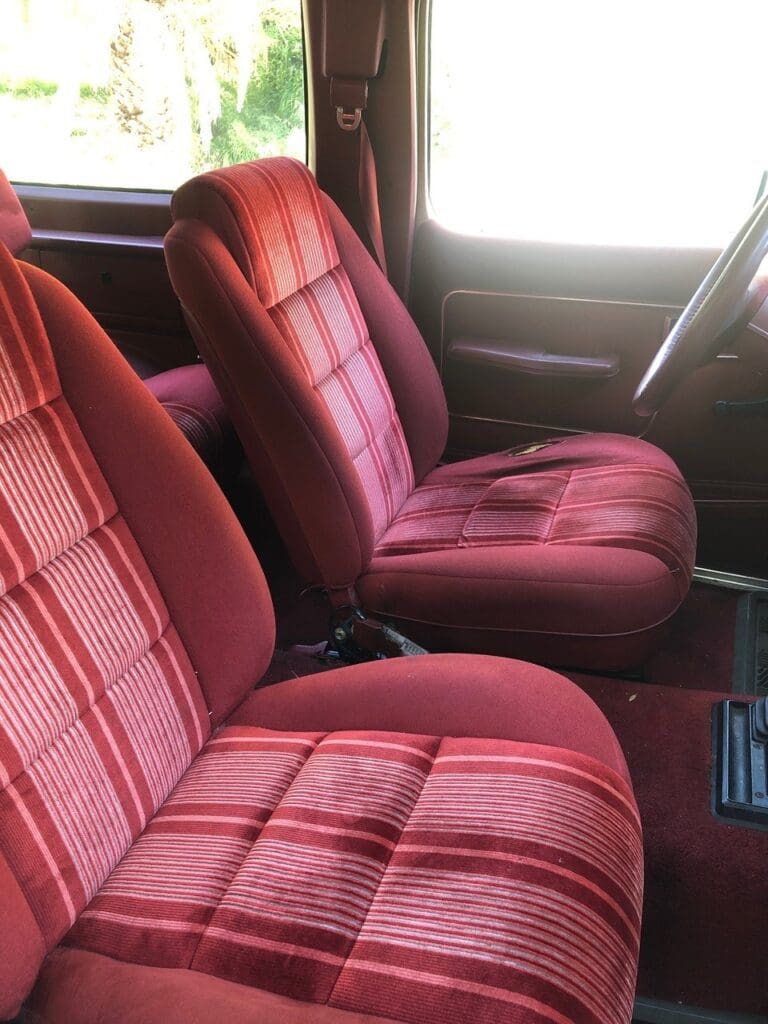 Vintage red plaid car seats inside a classic vehicle.