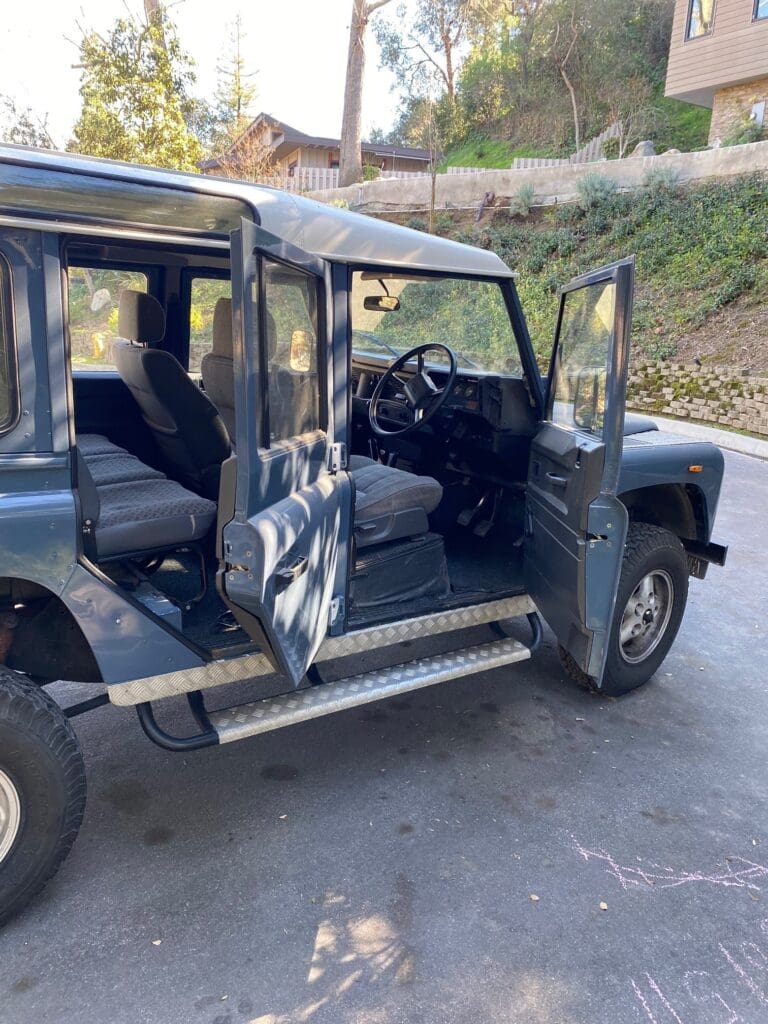 Black off-road vehicle with open doors parked outdoors.