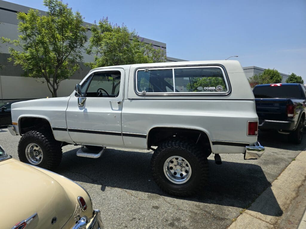 White vintage SUV parked outdoors under clear skies.