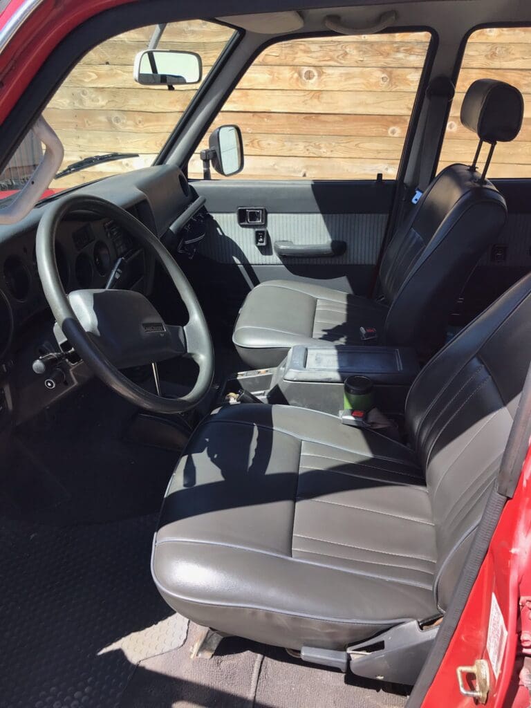 Interior of a car showing the steering wheel and front seats.