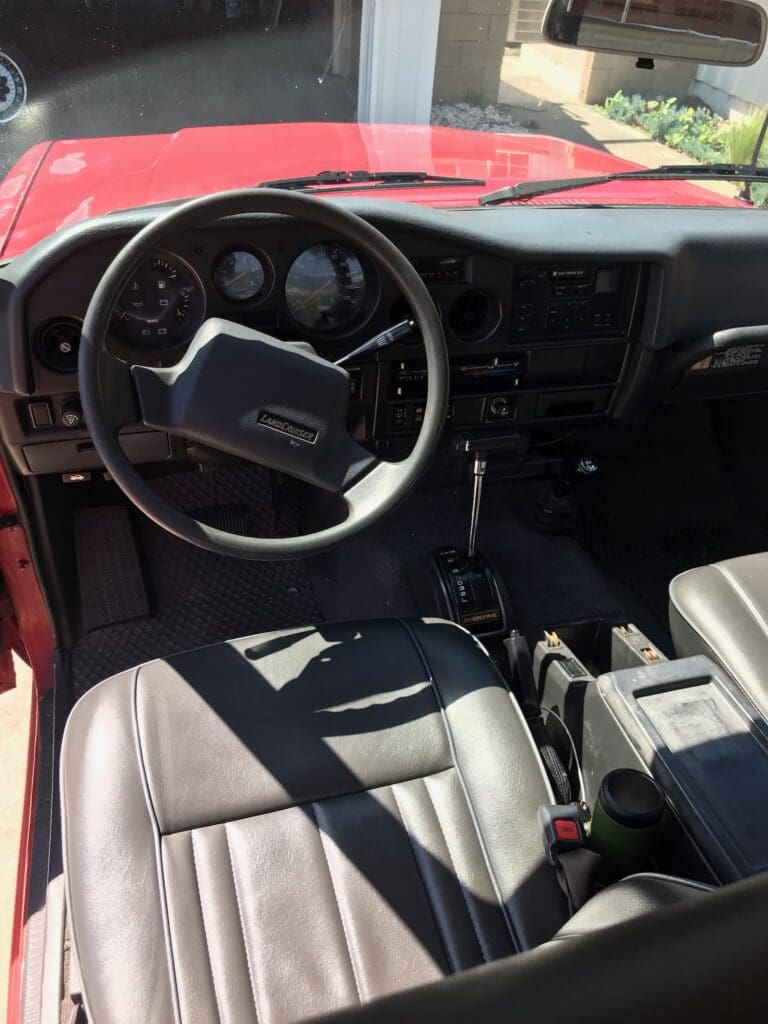 Interior view of a classic car with a steering wheel and dashboard.