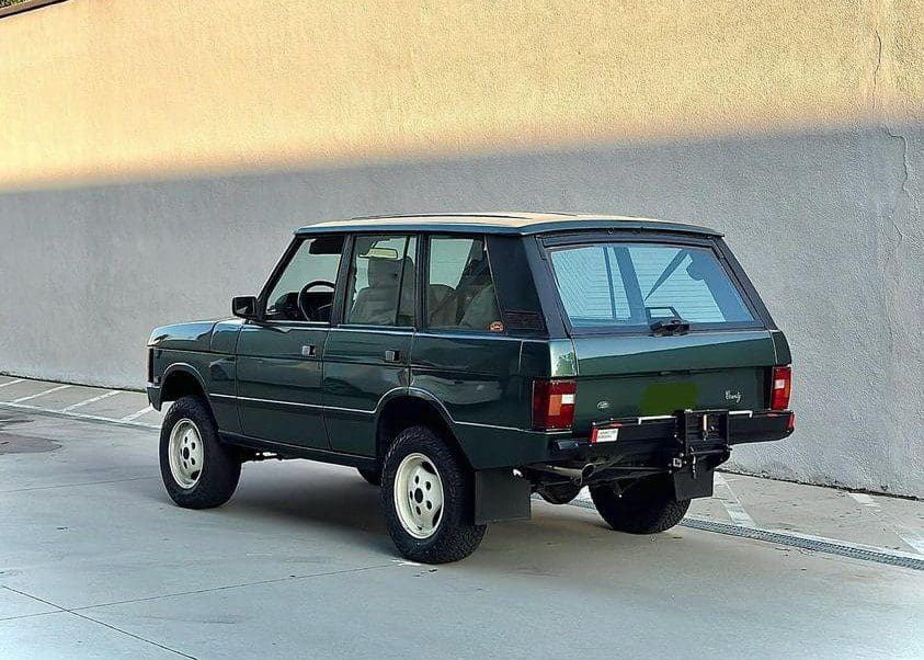 Classic green Range Rover parked outdoors with vintage design.