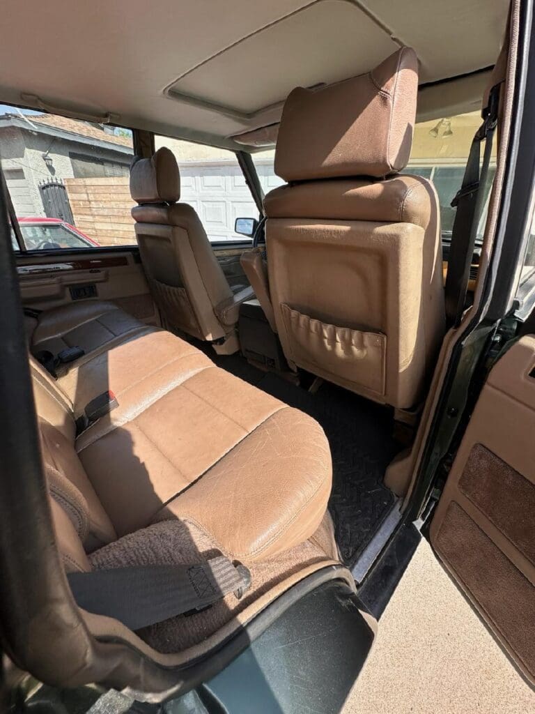 Spacious rear seating area with brown leather upholstery in a vehicle.