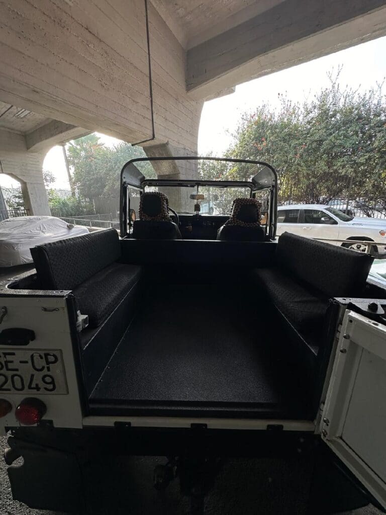 Empty pickup truck bed with open tailgate under a covered area.