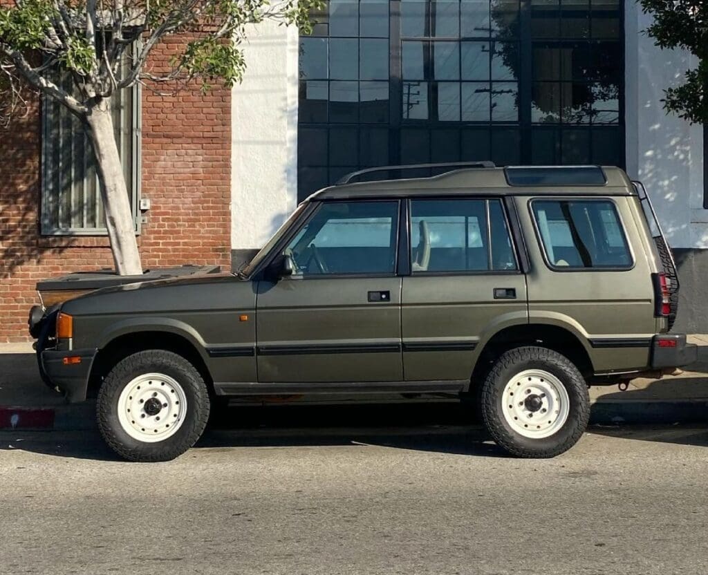 Side view of a dark green SUV parked on a street.