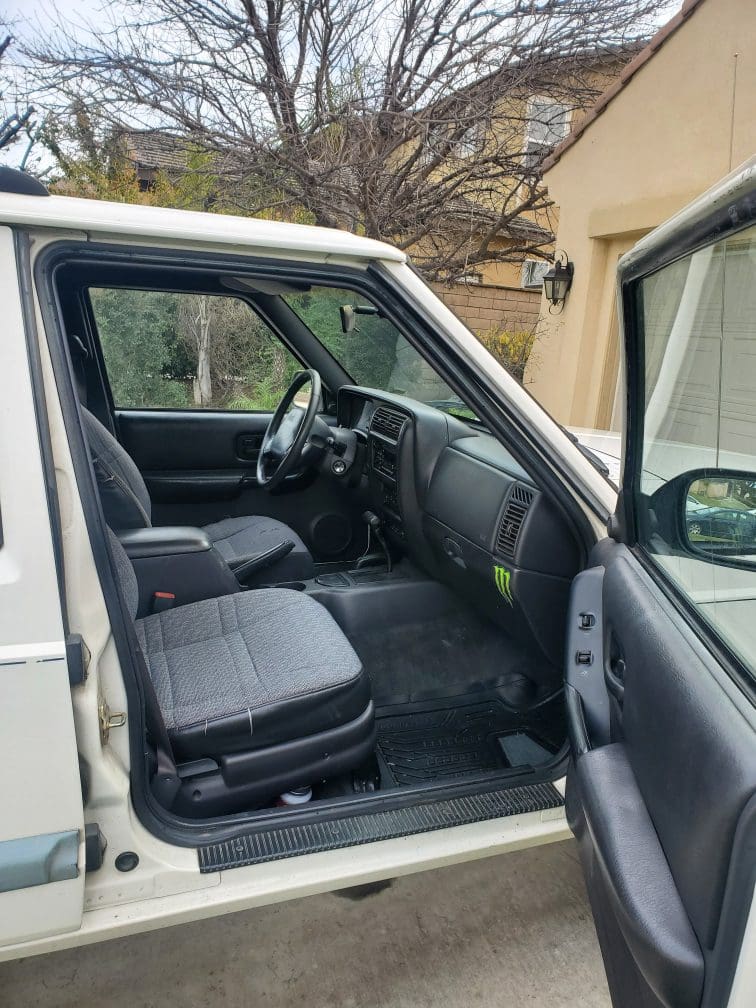 Interior view of a clean, grey fabric car seat and dashboard.