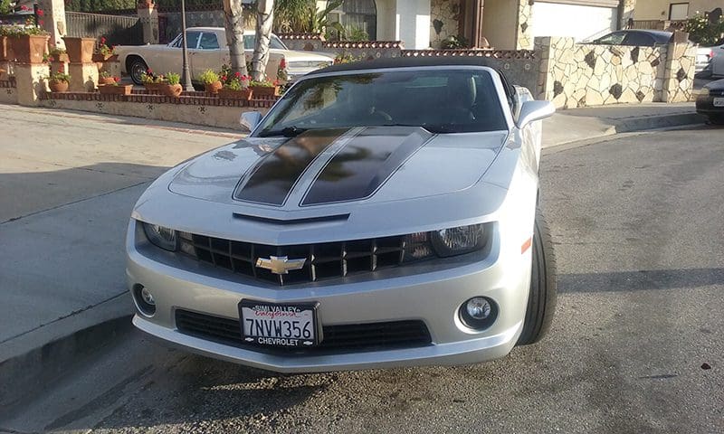 Silver Chevrolet Camaro parked on a residential street.