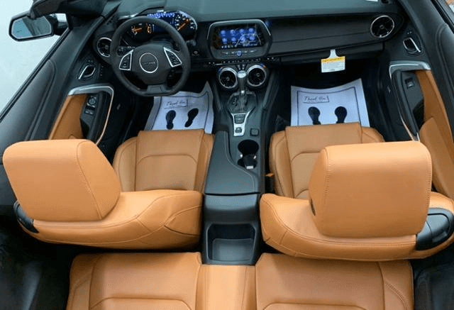 Luxury car interior with tan leather seats and modern dashboard.
