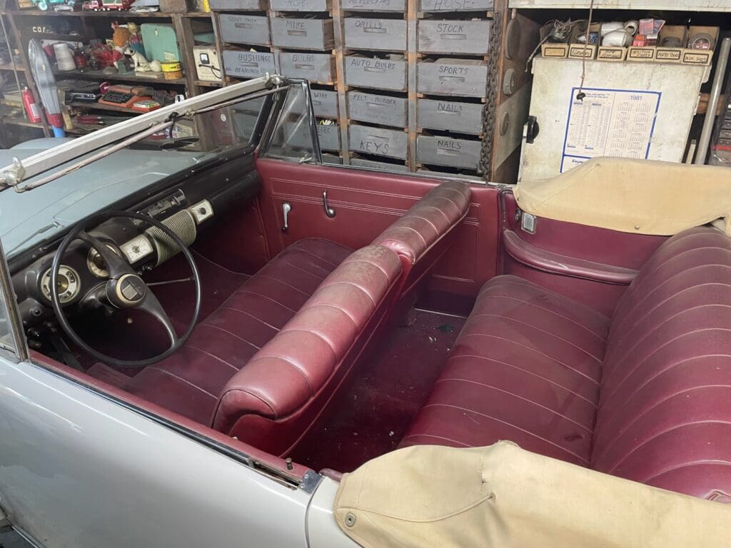 Interior of a vintage car with red leather seats and classic dashboard.