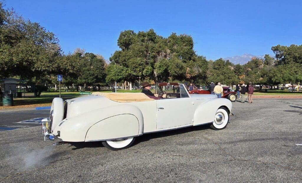Classic white convertible car parked outdoors on a sunny day.