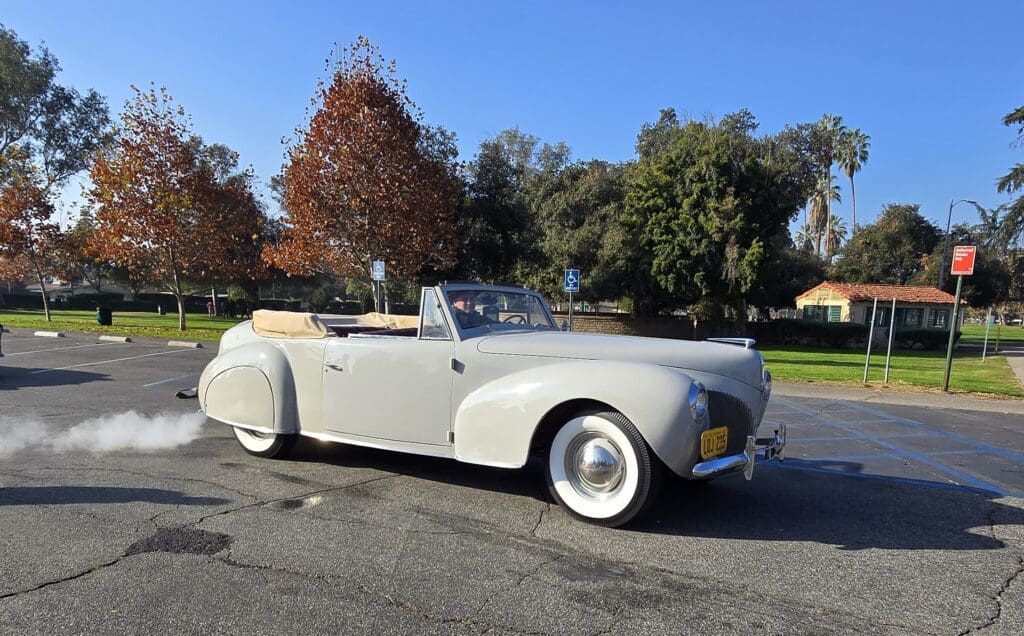 Classic white convertible car parked on a sunny street.