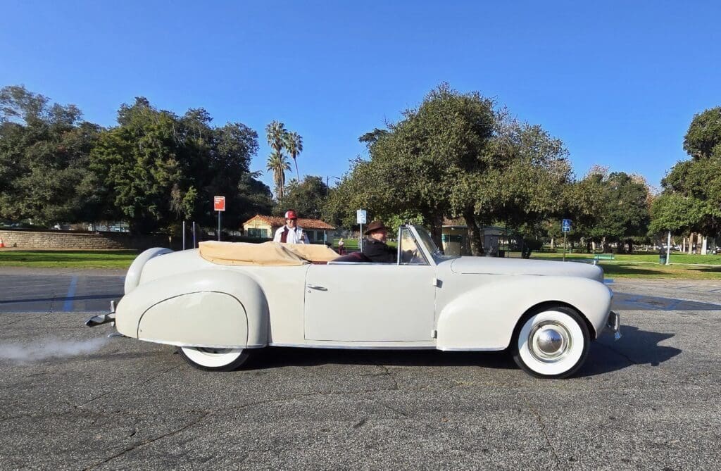 Classic white convertible car parked on a sunny day.