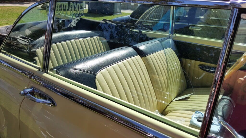 Vintage convertible car with beige leather seats and a black center accent.