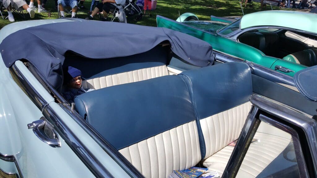 Convertible car interior with blue and white leather seats.