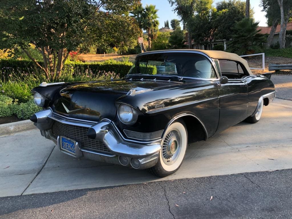 Classic black vintage car parked on a sunny street.