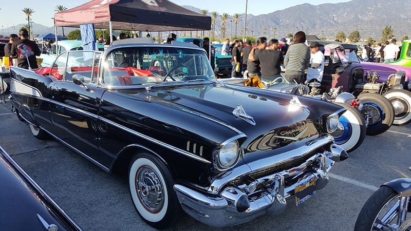 Classic black vintage car displayed at an outdoor car show.
