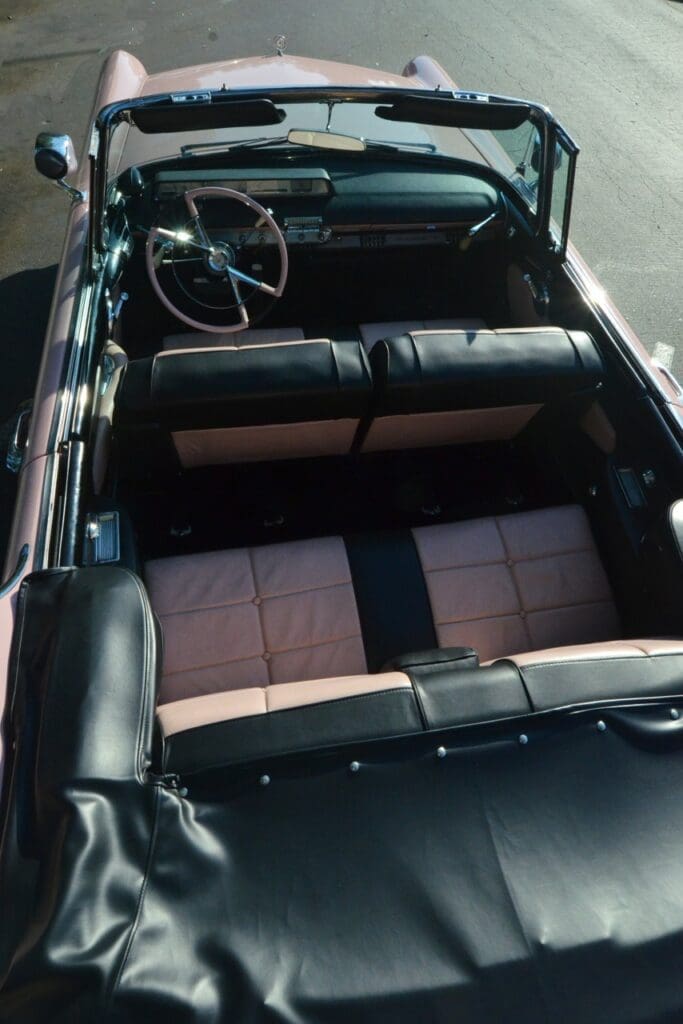 Interior view of a classic convertible car with black and beige seats.
