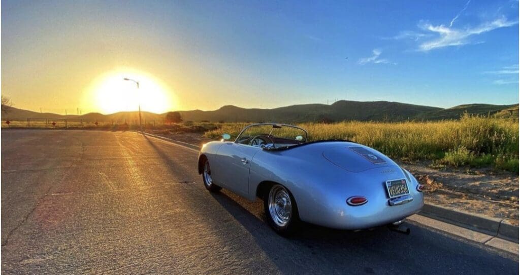 Convertible sports car on a sunny rural road at sunset.