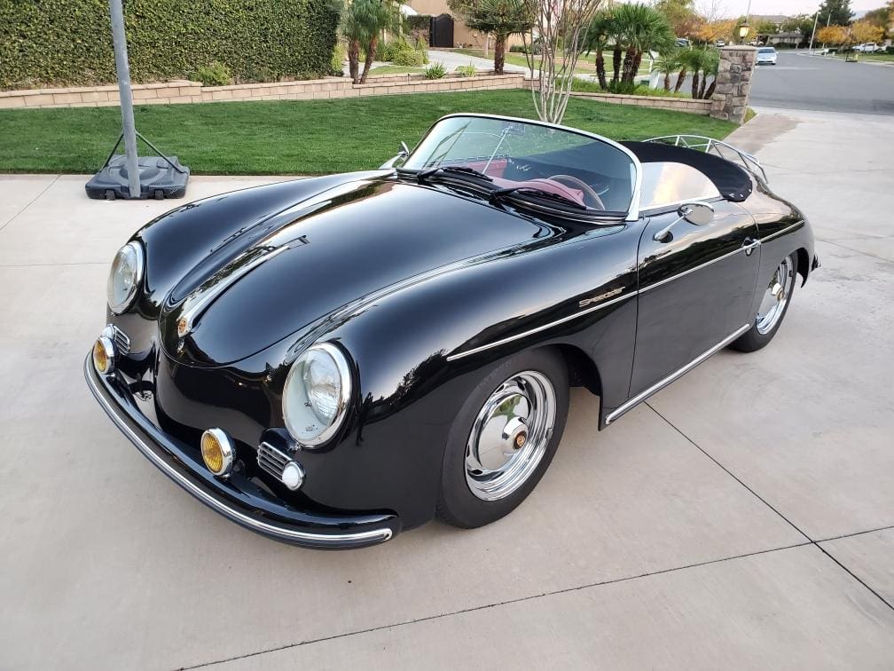 Classic black convertible sports car parked on driveway.