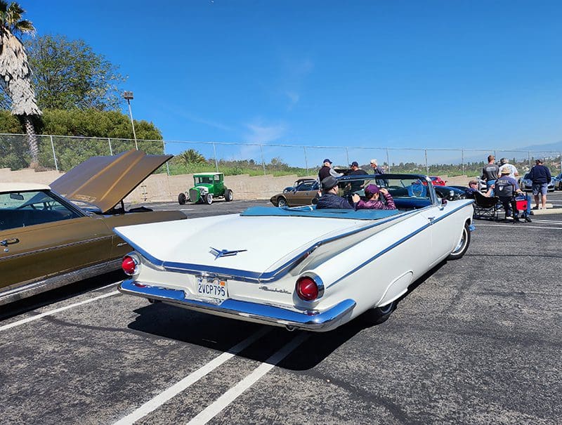 Classic white convertible car parked outdoors with clear blue sky.
