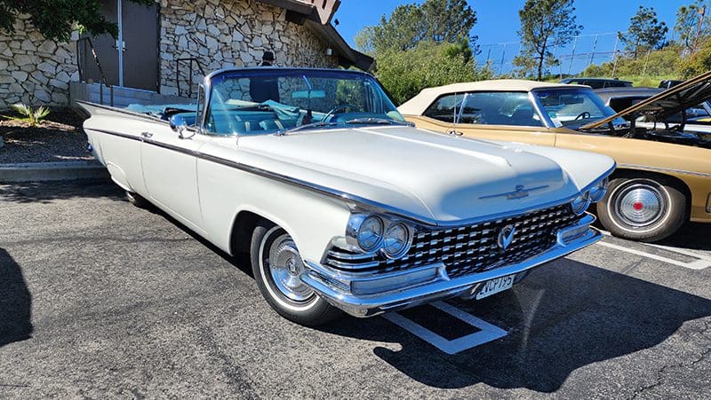 Classic white Buick convertible parked outdoors on a sunny day.