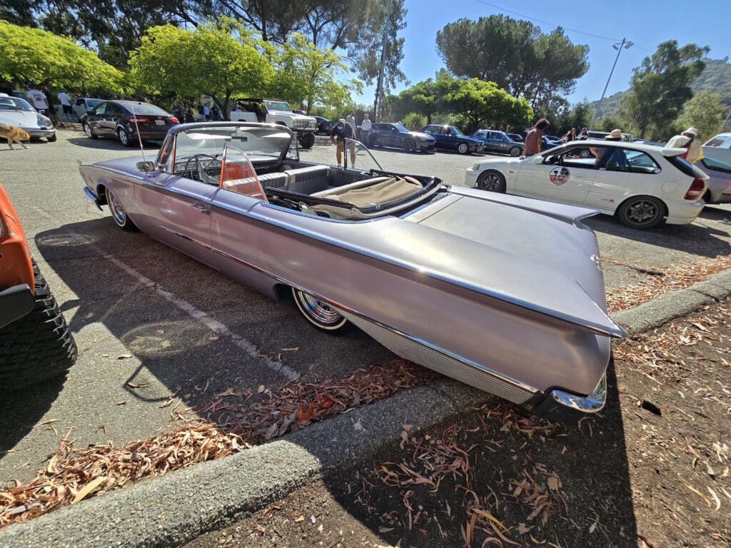 Classic convertible car parked in a sunny outdoor lot.