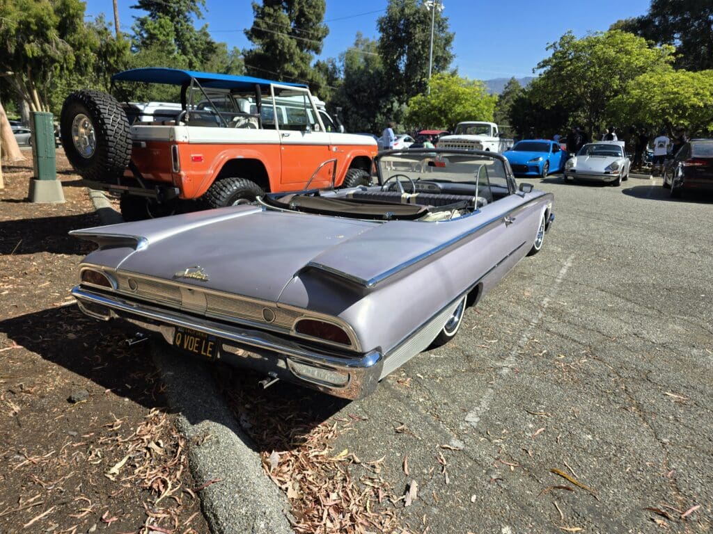 Classic silver convertible car parked outdoors on a sunny day.
