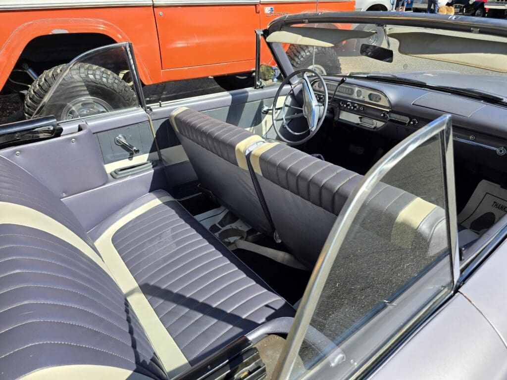 Interior view of a classic convertible car with blue and white seats.