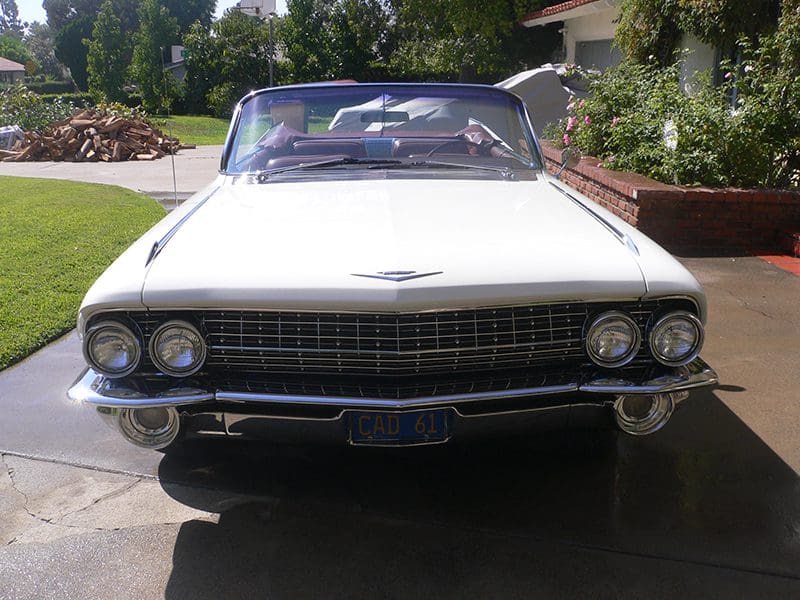 Front view of a classic white convertible car parked outdoors.