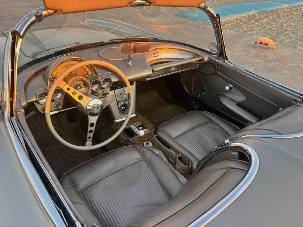 Interior of a classic convertible car with wooden steering wheel and leather seats.