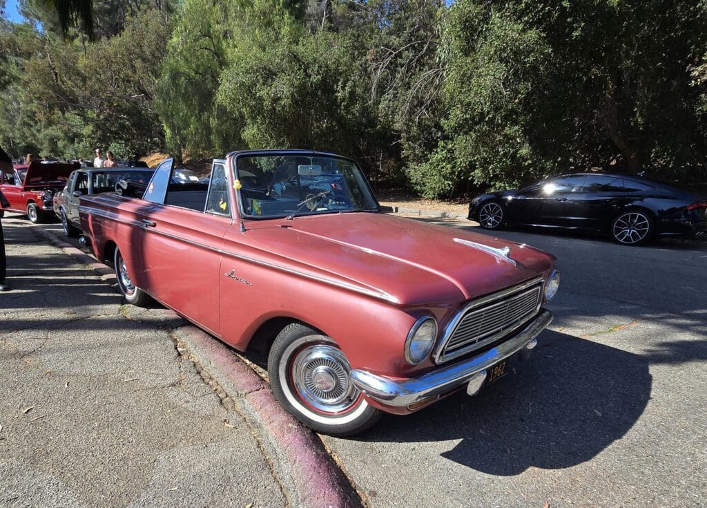 Classic red convertible car parked on a sunny day.