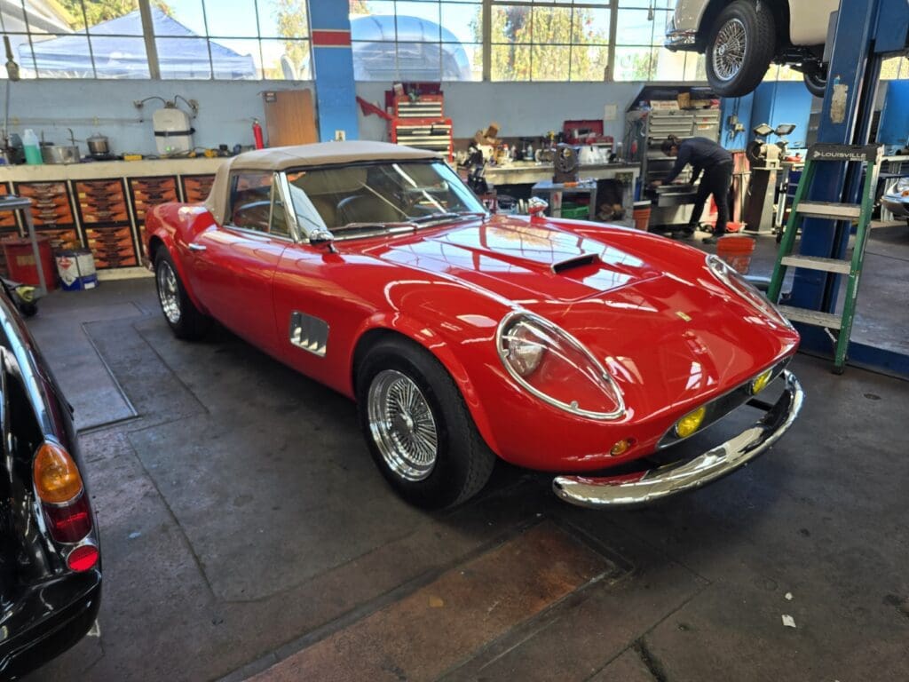 Classic red sports car displayed indoors.