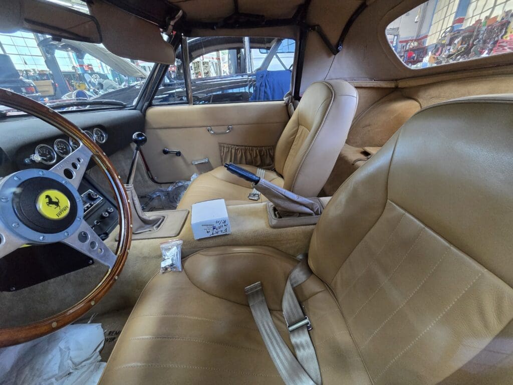 Interior of a vintage car with tan leather seats and classic dashboard.