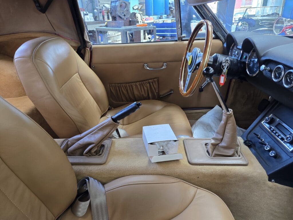 Luxurious tan leather car interior with modern gear shift and controls.