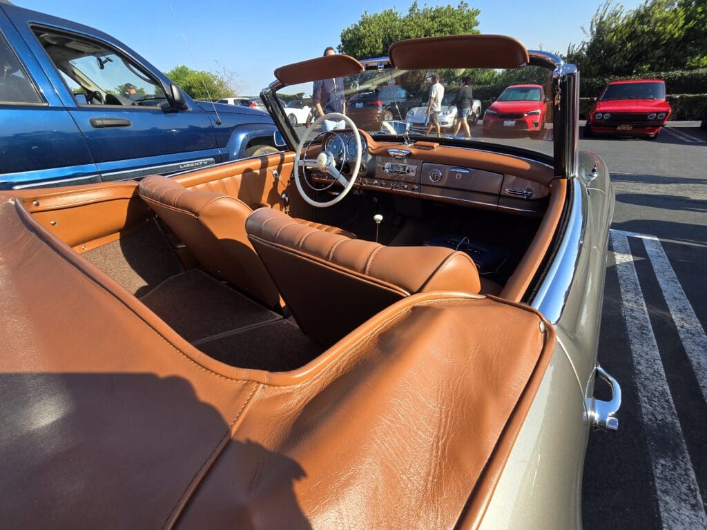 Classic black convertible car parked outdoors under a clear sky.