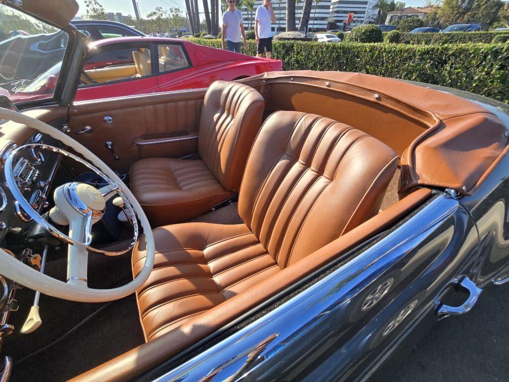 Classic car interior with brown leather seats and a wooden dashboard.