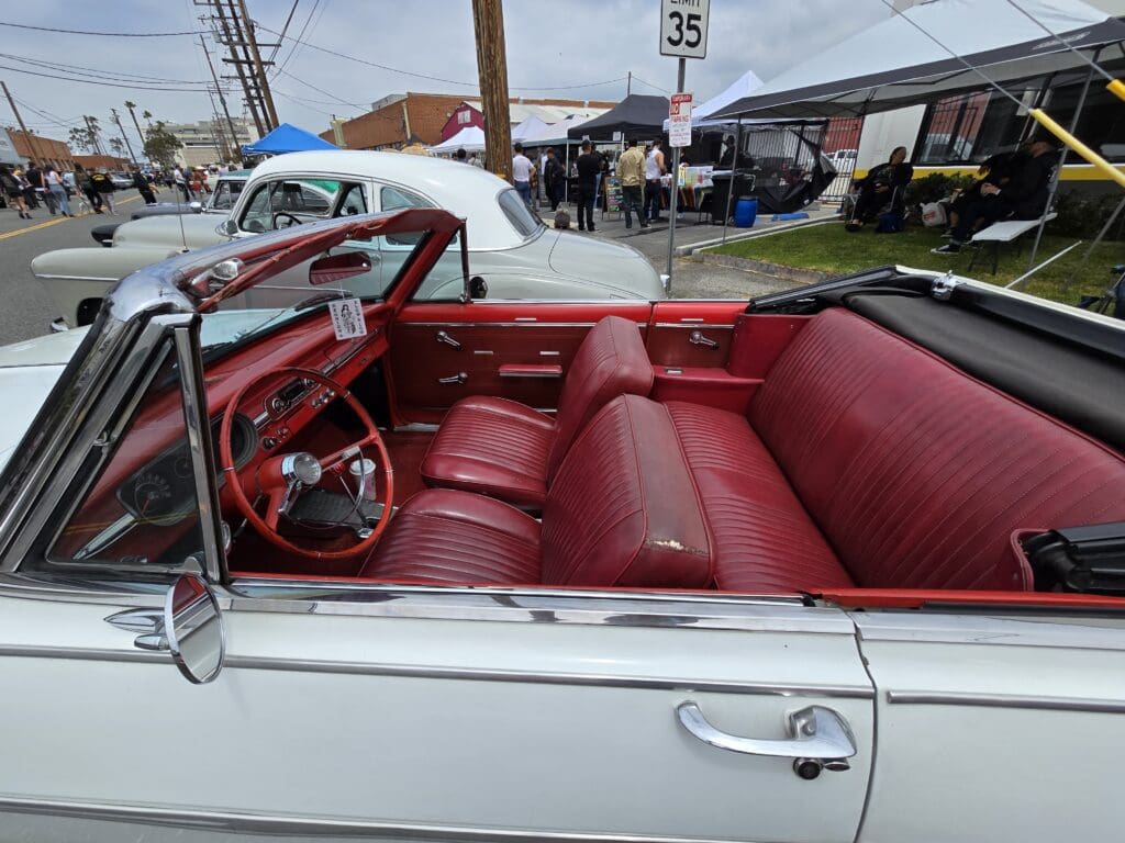 Classic white convertible car with red interior seats and dashboard.